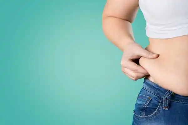 Image of woman pinching her love handles to show weight gain Leicester
