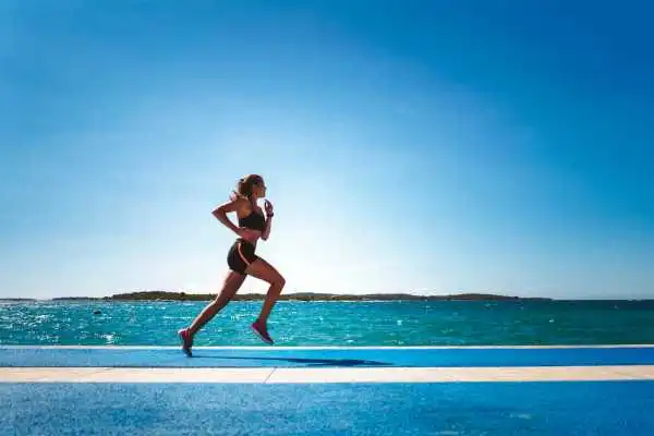 Woman running showing strong leg muscle Leicester